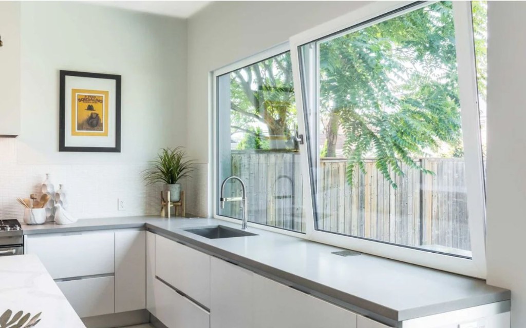 Cocina moderna con ventana oscilobatiente de PVC y vista al jardín